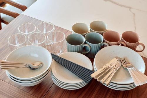 a table with plates and forks and empty glasses at Villa Noël Hakone Skylight Sauna & Open Air Bath in Hakone