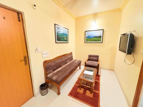 a living room with a couch and a tv at Hotel Vice President - Navrangpura, Ahmedabad in Ahmedabad