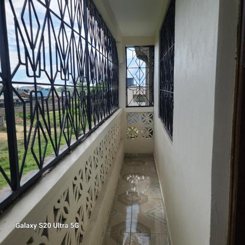 a hallway with stained glass windows and a tiled floor at Wema centre apartment in Gatunga