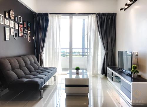 a living room with a couch and a television at Ipoh Majestic Premium Suites by Verve in Ipoh