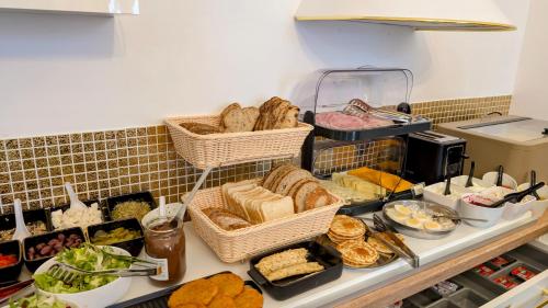 a buffet with baskets of bread and other food at Polpo Apartments B&B in Łódź