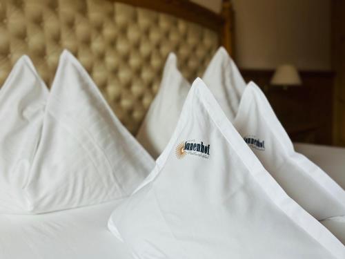 a group of white hotel pillows on a bed at Naturhotel Sonnenhof in Chiusa