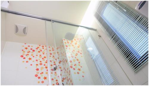 a shower with a shower curtain with flowers on it at Errantry Lodge & Studio in Hualien City
