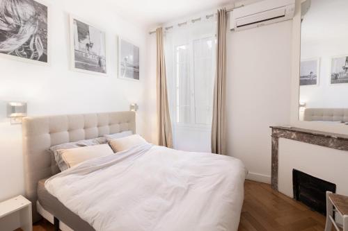 - une chambre avec un lit blanc et une cheminée dans l'établissement Center of Cannes 100m2 bright apartment, à Cannes