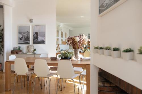 une salle à manger avec une table en bois et des chaises blanches dans l'établissement Center of Cannes 100m2 bright apartment, à Cannes