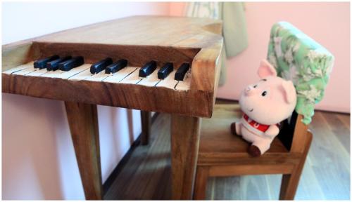 a wooden keyboard with a toy pig sitting next to a chair at Errantry Lodge & Studio in Hualien City