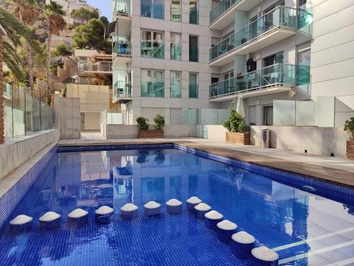 ein Schwimmbad vor einem Gebäude in der Unterkunft MIRADOR lovely apartment in Benidorm