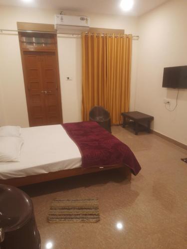 a bedroom with a bed and a door with a window at Hotel 24-7 in Nagpur