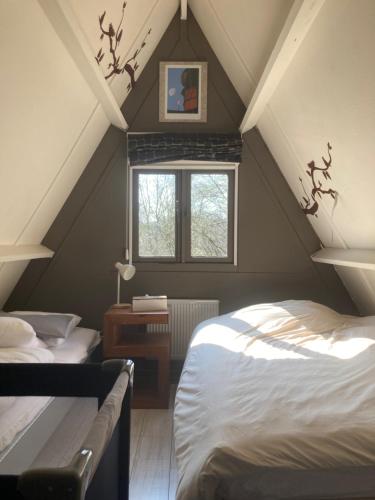 a attic room with two beds and a window at Chalet Séquoia 138 Nature, piscine et chien bienvenu à Durbuy in Durbuy