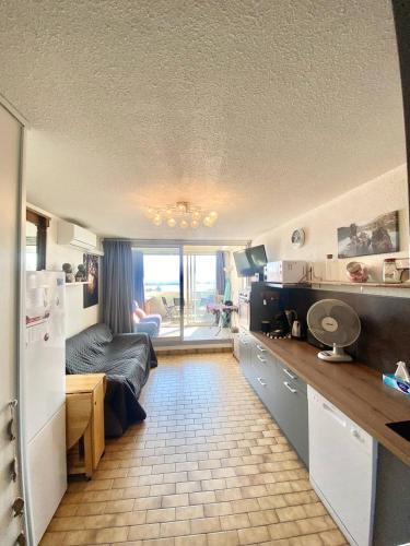 une pièce avec une cuisine et un salon dans l'établissement studio cabine piscine proche des plages 4 personnes, au Grau-du-Roi