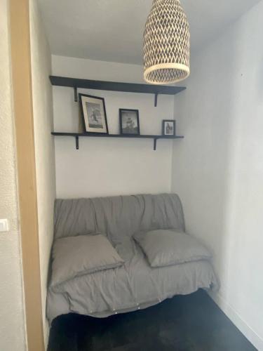 - un canapé dans un coin d'une pièce avec un lustre dans l'établissement SUPERBE STUDIO 4 PERSONNES - TERRASSE- PARKING- PISCINE, au Grau-du-Roi