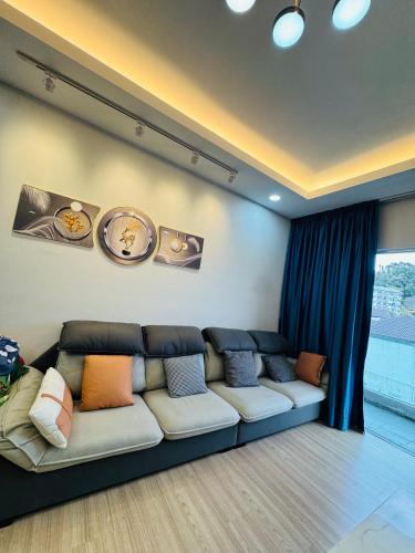 a living room with a couch with pillows on it at AYAAN PLATINUM Foosball Home at Quintet Apartment Free Parking in Tanah Rata