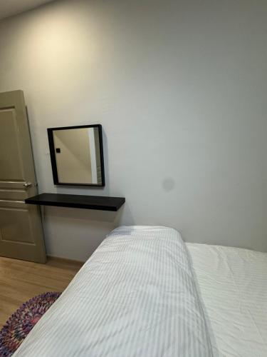 a bedroom with a bed and a mirror on a wall at AYAAN PLATINUM Foosball Home at Quintet Apartment Free Parking in Tanah Rata
