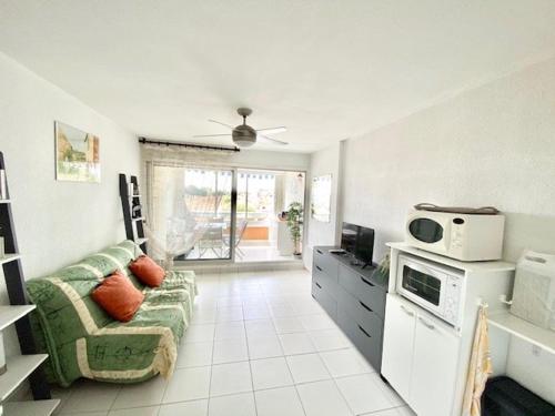 - un salon avec un canapé et un four micro-ondes dans l'établissement STUDIO CABINE 4 PERSONNES + GARAGE, au Grau-du-Roi