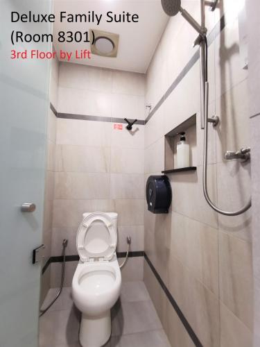 a small bathroom with a toilet and a shower at Mwv Family Suite Room in Muar