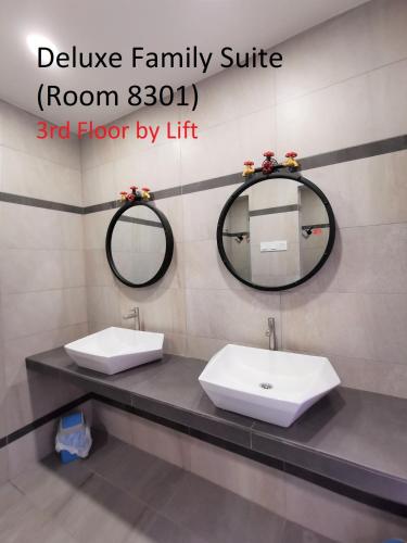 a bathroom with two sinks and a mirror at Mwv Family Suite Room in Muar