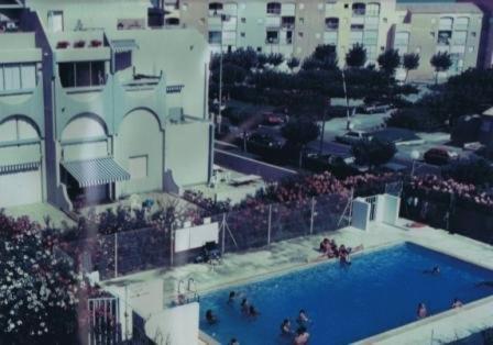 une vue aérienne d'une piscine dans une ville dans l'établissement APPARTEMENT CHAMBRE + COIN CABINE dans résidence avec piscines., au Grau-du-Roi