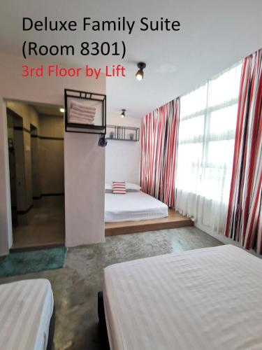 a bedroom with two beds and a room with a window at Mwv Family Suite Room in Muar