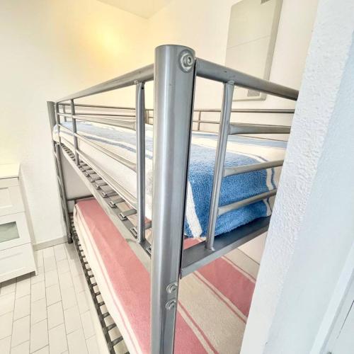 - un escalier dans une chambre avec des lits superposés dans l'établissement SECTEUR SEAQUARIUM - APPARTEMENT 6 PERS CLIMATISE RDC, 1 CHAMBRE - GRANDE TERRASSE, au Grau-du-Roi