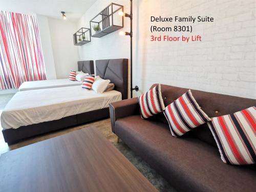 a living room with a couch and a bed at Mwv Family Suite Room in Muar