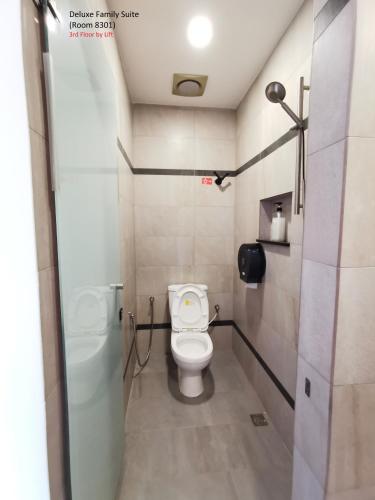 a bathroom with a toilet and a shower at Mwv Family Suite Room in Muar