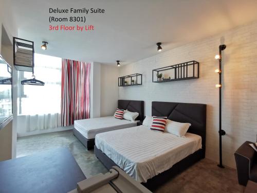 a hotel room with two beds and a window at Mwv Family Suite Room in Muar