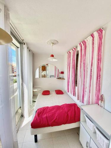 - une chambre avec un lit doté d'oreillers rouges dans l'établissement APPARTEMENT 1 CHAMBRE, 6 PERSONNES DANS RESIDENCE AVEC PISCINES, au Grau-du-Roi