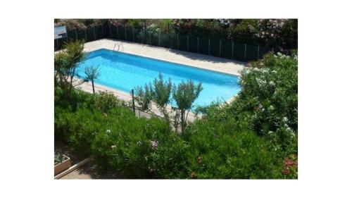une vue aérienne d'une piscine dans un jardin dans l'établissement APPARTEMENT 1 CHAMBRE, 6 PERSONNES DANS RESIDENCE AVEC PISCINES, au Grau-du-Roi