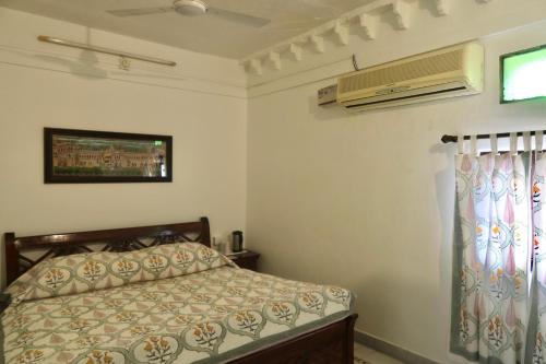 a bedroom with a bed and a air conditioner at Dev Niwas - Heritage Hotel in Būndi