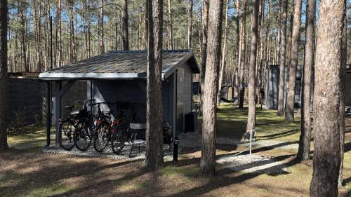 a shed with bikes parked in it in the woods at Las Biala's - Domki z sauną i jacuzzi w Puszczy Noteckiej - Tylko dla dorosłych in Biala