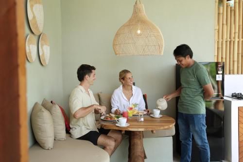 Hanaq Pacha Villas في كوتا لومبوك: مجموعة من الأشخاص يجلسون حول طاولة في غرفة