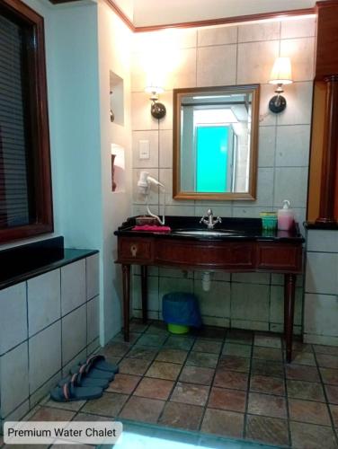 a bathroom with a sink and a mirror at Alpine Premium Water Chalet 2 in Port Dickson