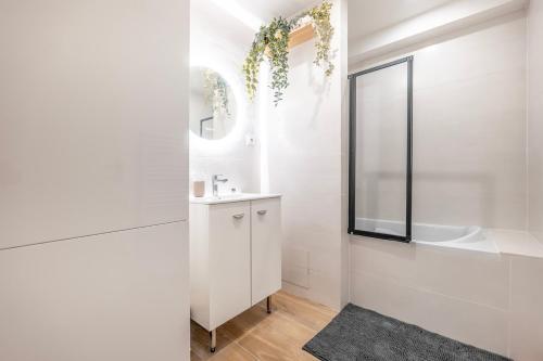 une salle de bain blanche avec un lavabo et un miroir dans l'établissement Serenity House, parking, near metro 7, à Villejuif