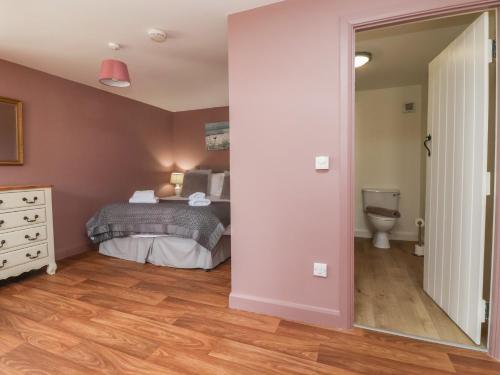 - une chambre avec un lit et des toilettes dans l'établissement The Cottage, à Thirsk