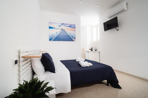 a white room with a bed and a tv at Puglia Mar in Mola di Bari