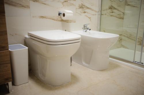 a white bathroom with a toilet and a sink at Puglia Mar in Mola di Bari