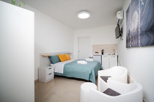 a bedroom with a bed and two white chairs at Puglia Mar in Mola di Bari