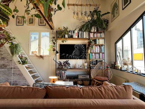 un salon avec un canapé et une télévision dans l'établissement Cozy apartment in a quiet alley, à Paris