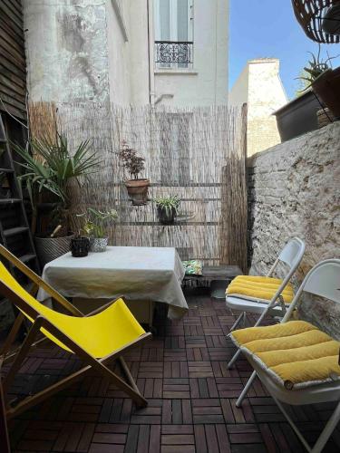 un patio avec une table et des chaises et une clôture dans l'établissement Cozy apartment in a quiet alley, à Paris