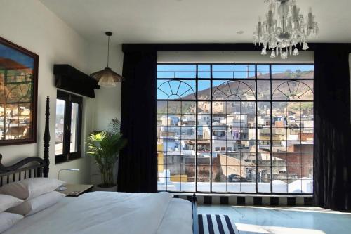 a bedroom with a large window with a view of a city at Dev Niwas - Heritage Hotel in Būndi