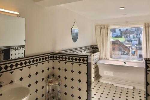 a bathroom with a tub and a sink and a window at Dev Niwas - Heritage Hotel in Būndi