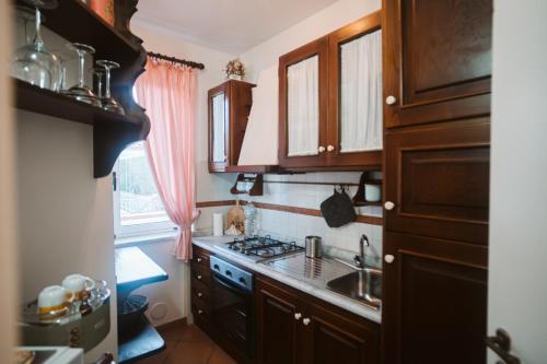 a small kitchen with wooden cabinets and a sink at Cilento Rooftop in Agropoli