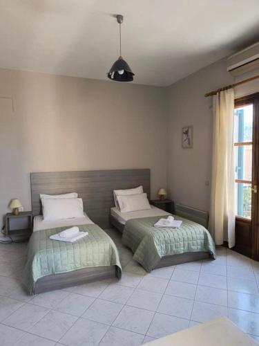 a bedroom with two beds and a window at Liber-Mar apartments in Petra