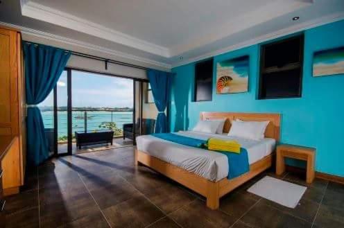 a bedroom with a bed with a blue wall at Residenceticoco in Grand-Baie