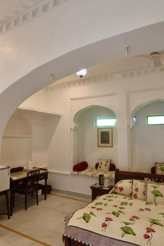 a bedroom with a bed and a table and a dining room at Dev Niwas - Heritage Hotel in Būndi