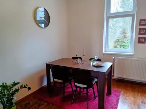 a dining room table with chairs and a mirror at Apartmán Waldruh s terasou in Jalŭvčí