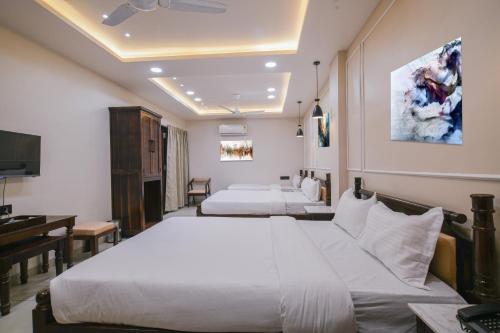 a hotel room with two beds and a desk at The Byke Boutique Mahakal Aangan - Pan India Pure Veg Hotel Chain in Ujjain