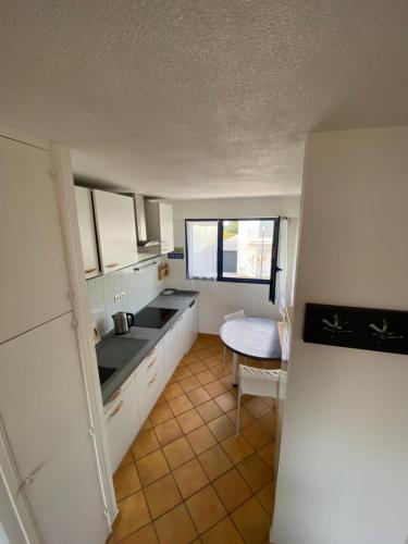 Una cocina con un refrigerador y una mesa dentro. en Duplex 100m de la mer, en Larmor-Plage