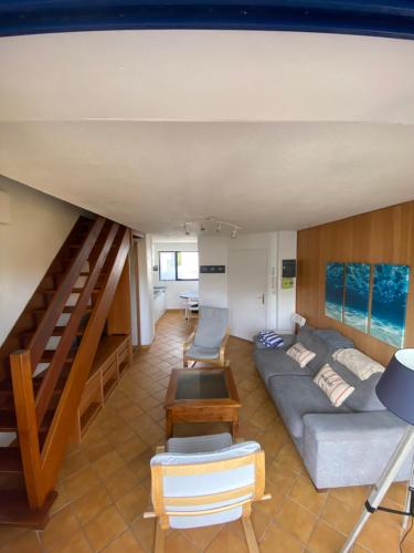 un salon avec un canapé et un escalier dans l'établissement Duplex 100m de la mer, à Larmor-Plage
