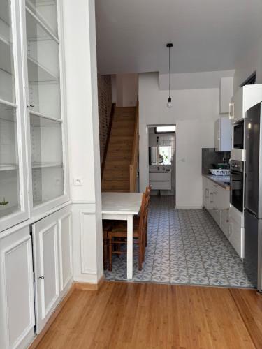 une cuisine et une salle à manger avec une table et des armoires dans l'établissement Chambre meublée au calme dans maison de caractère Hyper centre 3m Gare, à Amiens